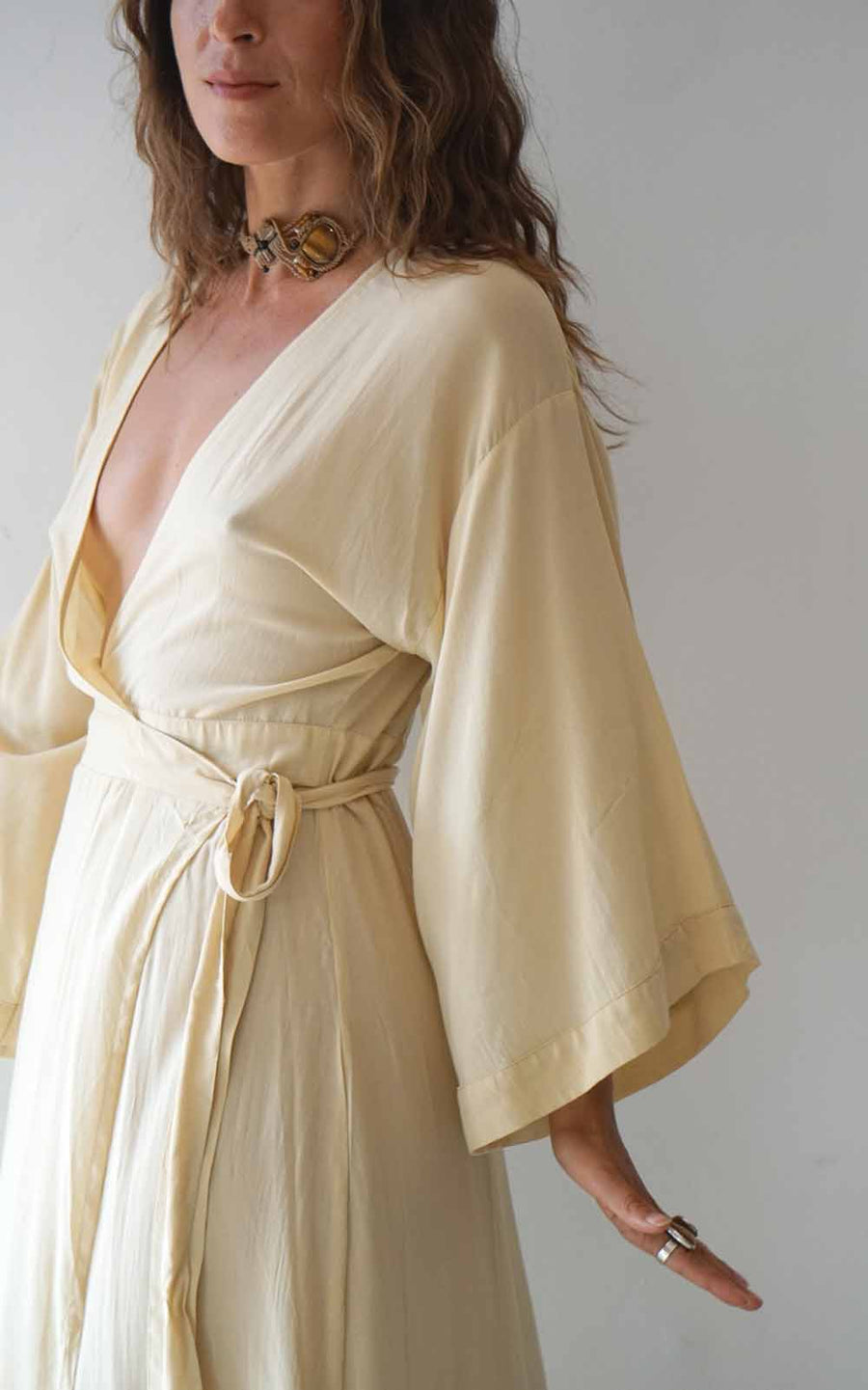 Woman wearing a light yellow dress with a plain background