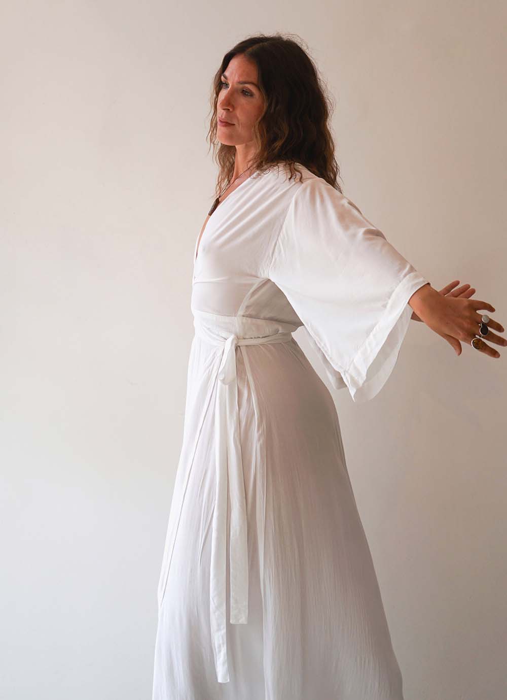 Woman wearing a white robe against a plain background