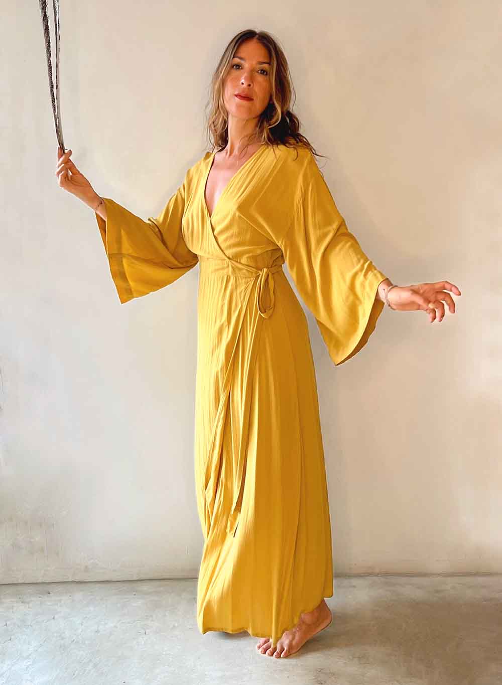 Woman wearing a yellow dress against a plain background