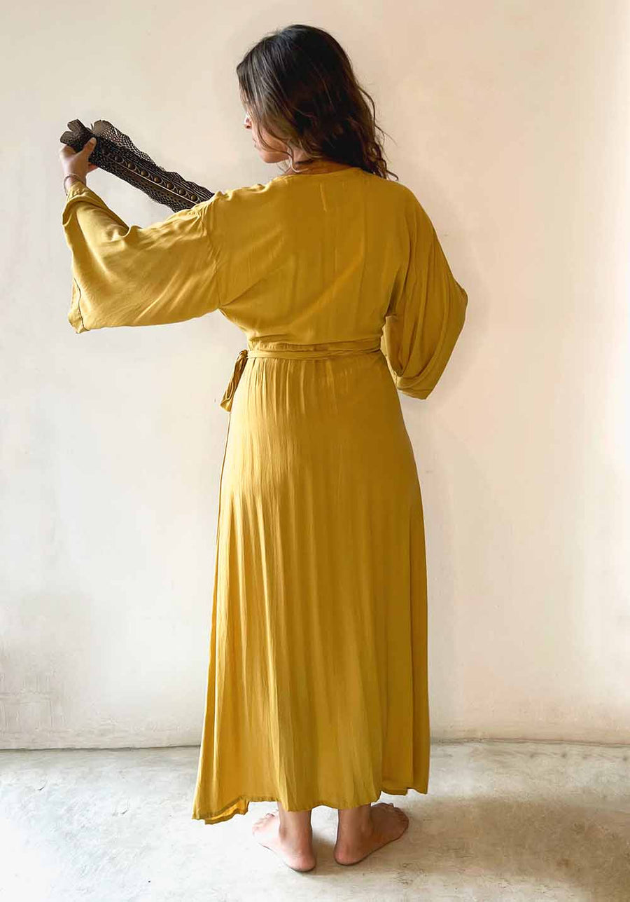 Woman wearing a yellow dress against a plain background
