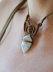 Necklace with a stone pendant on a person's neck