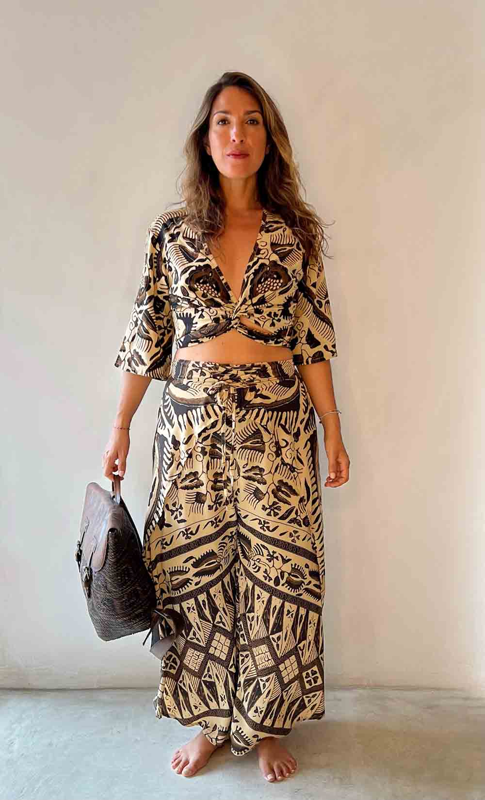 Woman wearing a black and white patterned outfit against a plain background