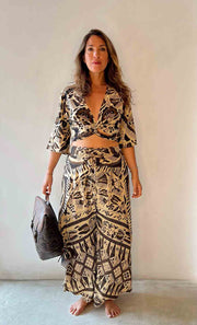 Woman wearing a black and white patterned outfit against a plain background
