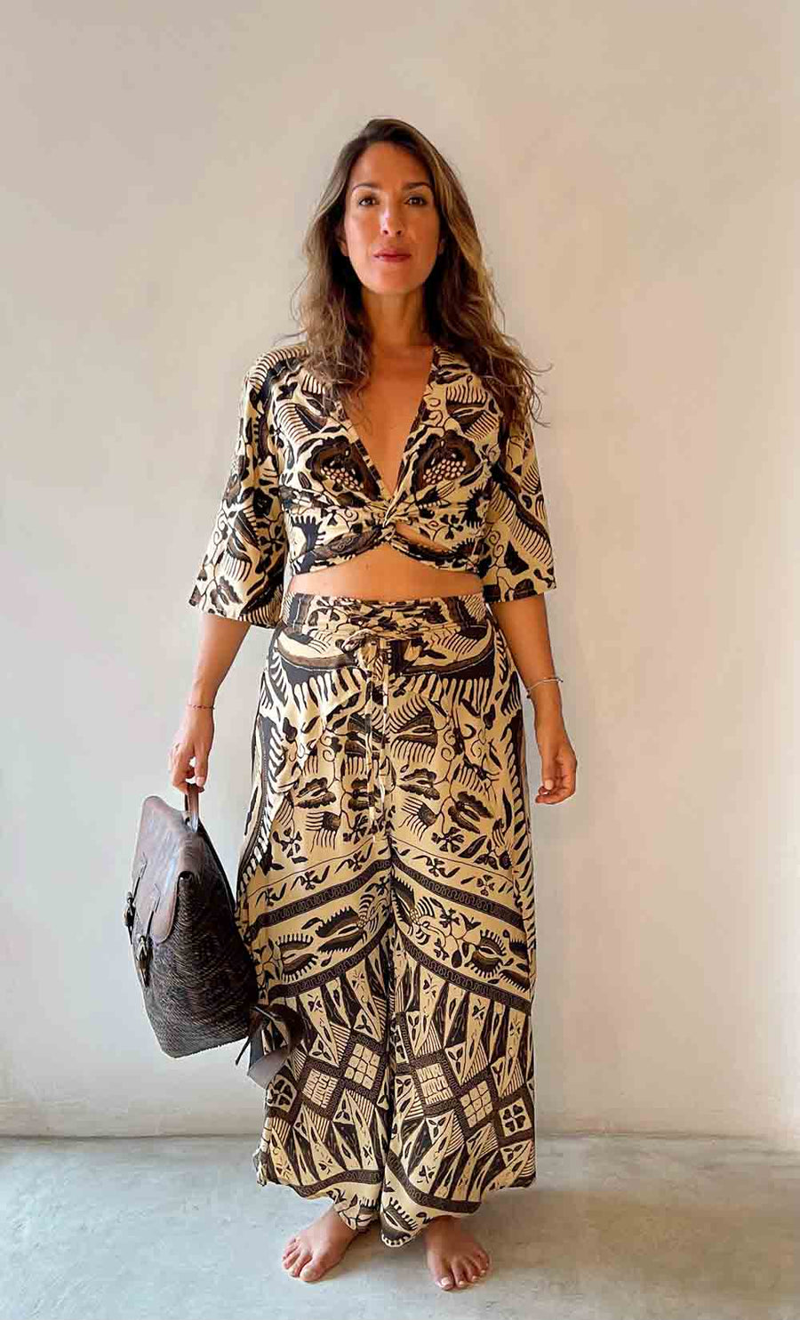 Woman wearing a black and white patterned outfit against a plain background