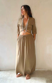 Woman wearing a beige outfit with a plain background