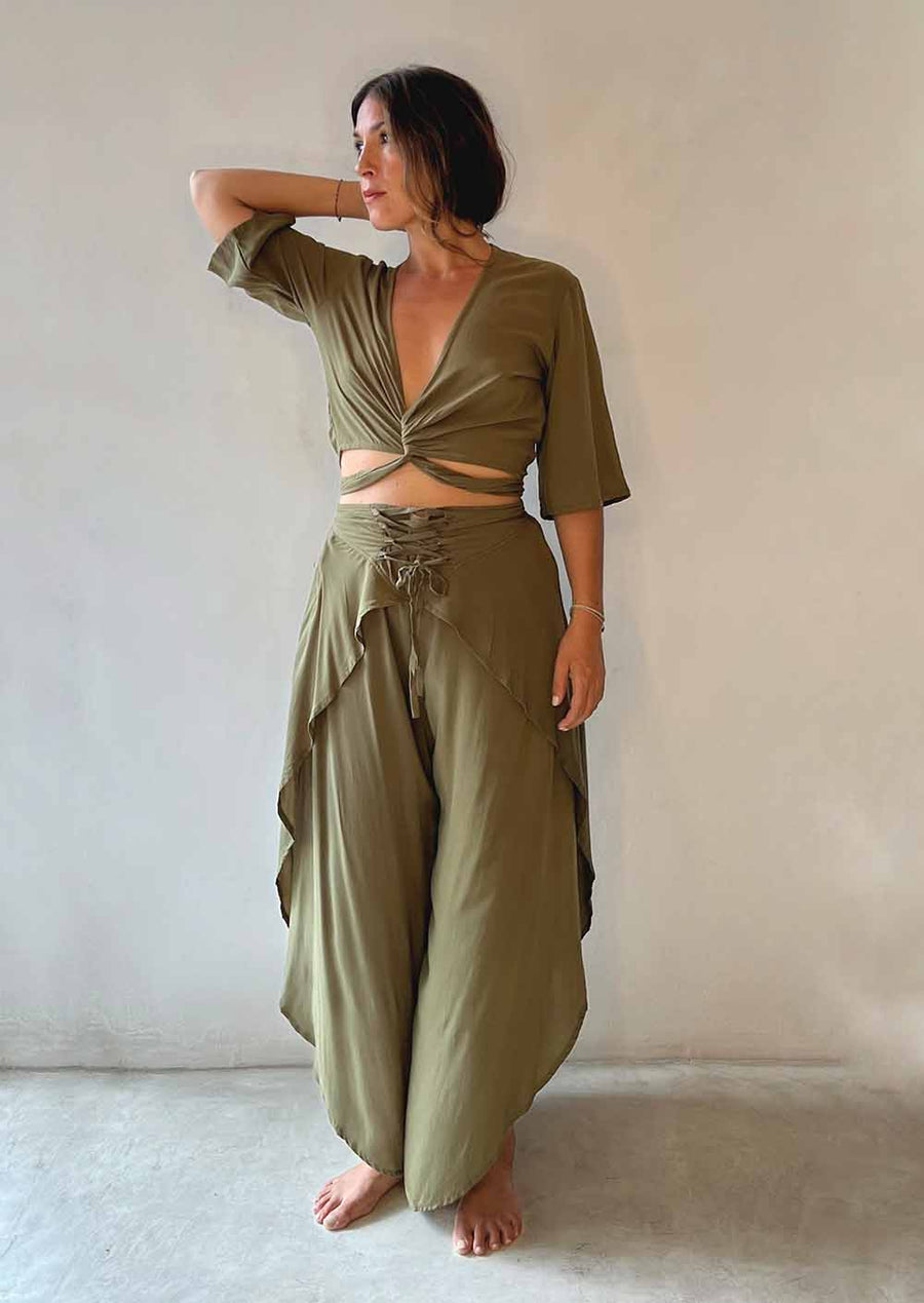 Woman wearing an olive green outfit with a plain background