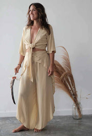 Woman wearing a beige outfit with a plain background