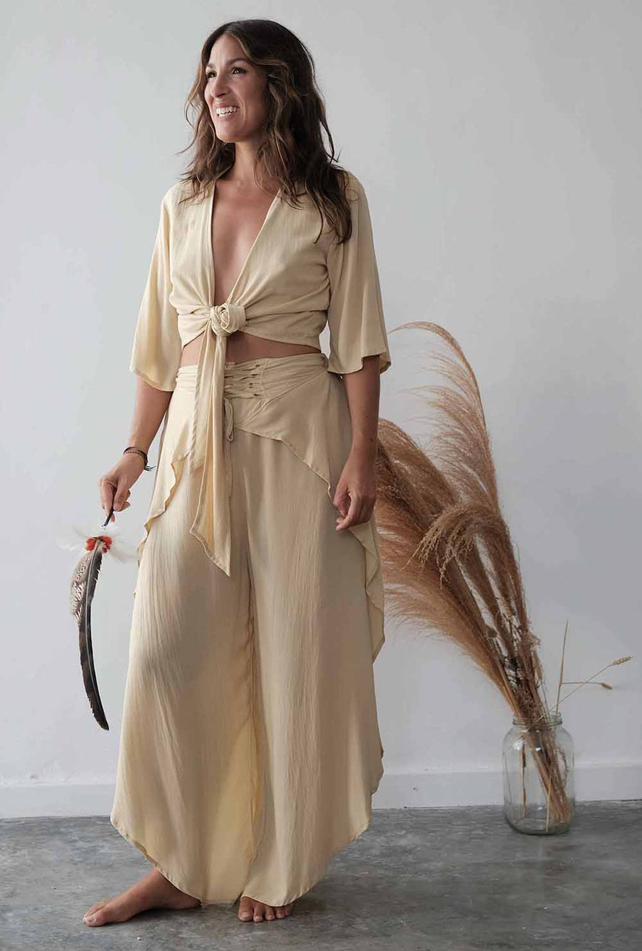 Woman wearing a beige outfit with a plain background