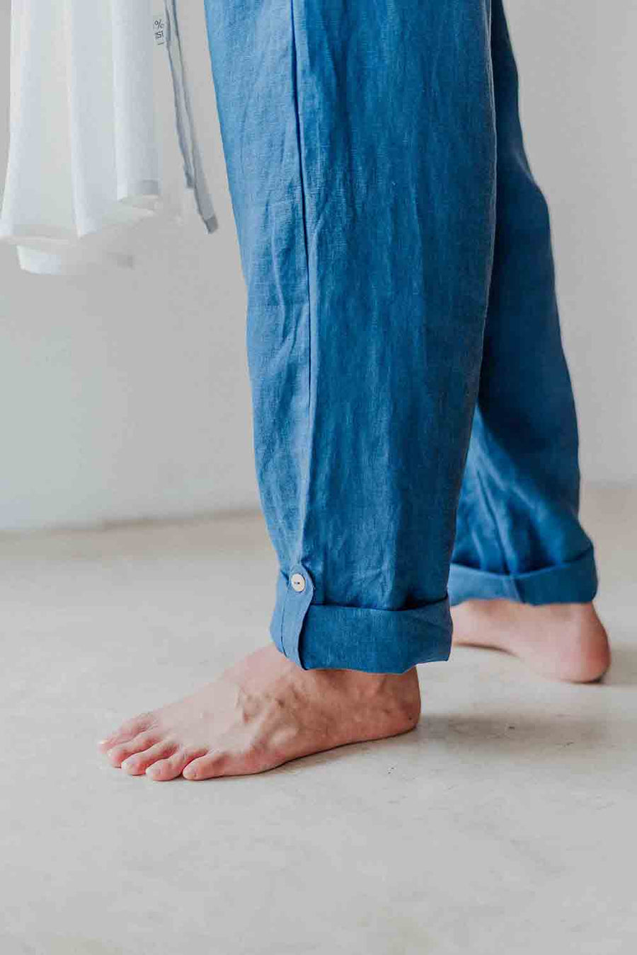 Blue pants worn by a person on a light background