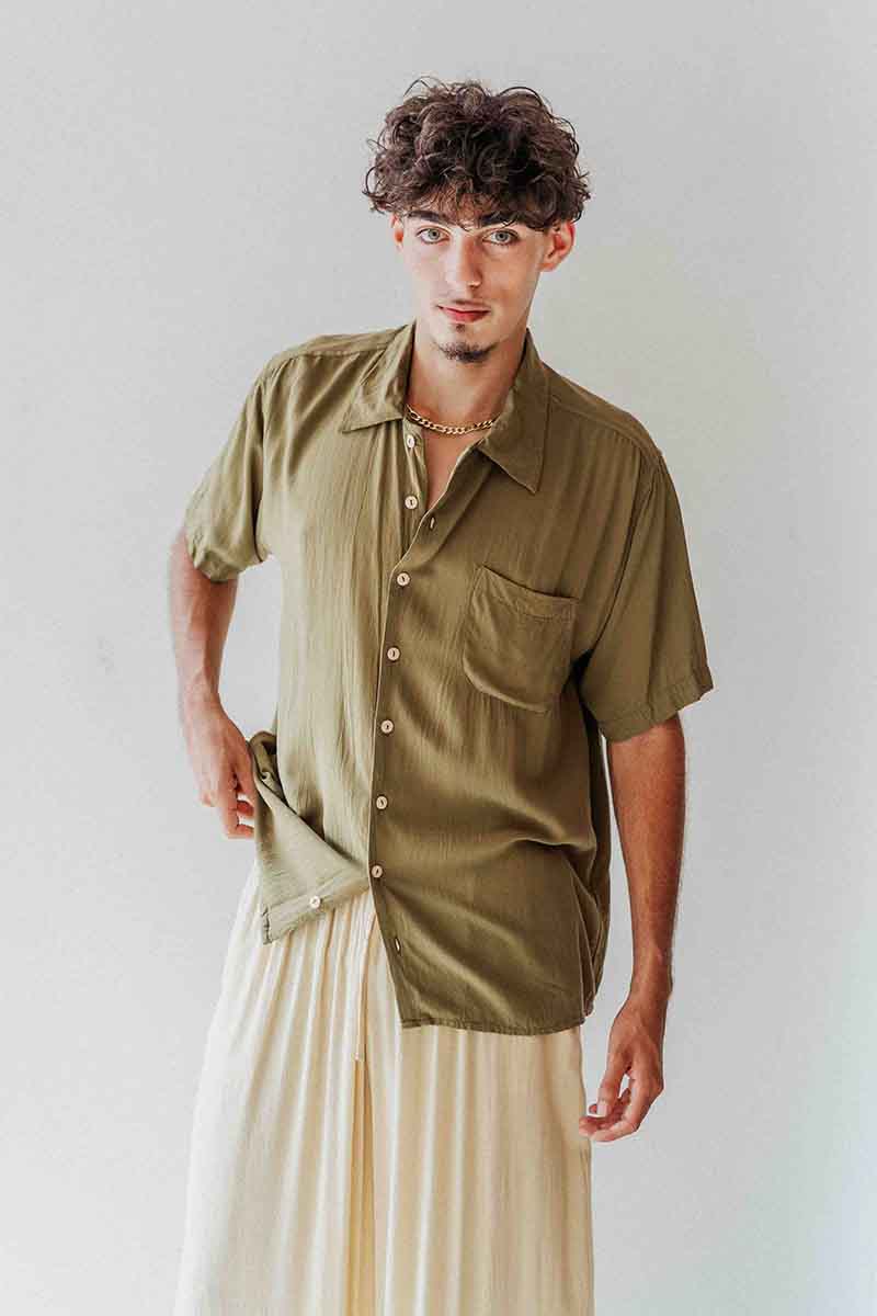 Man wearing an olive green shirt with a white background