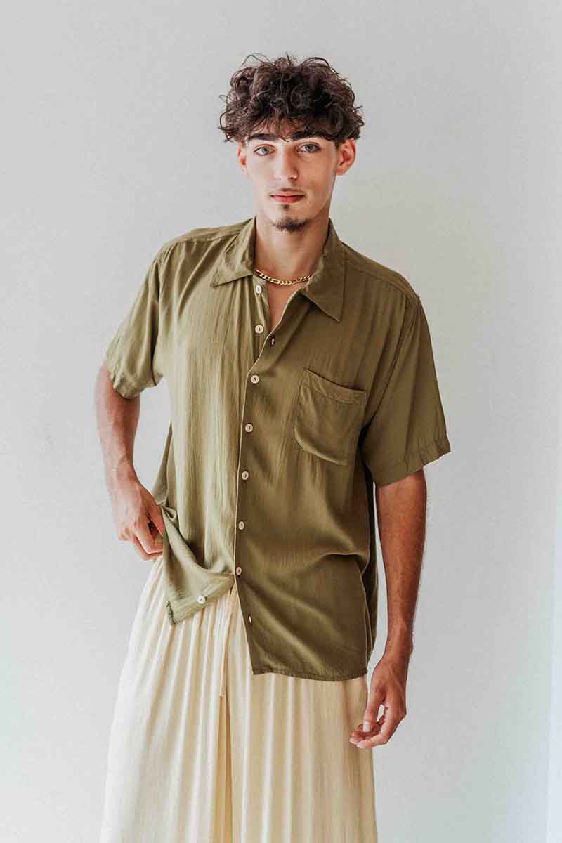 Man wearing an olive green shirt with a plain background