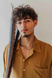 Man wearing a mustard yellow shirt with a neutral background