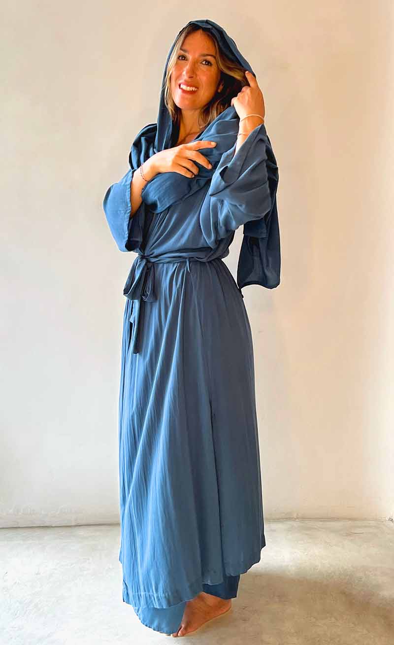 Woman wearing a blue robe against a plain background