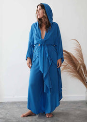 Woman wearing a blue outfit with a hood in a minimalistic setting