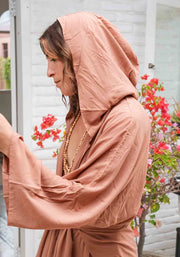 Woman wearing a peach-colored hijab and dress with a blurred background