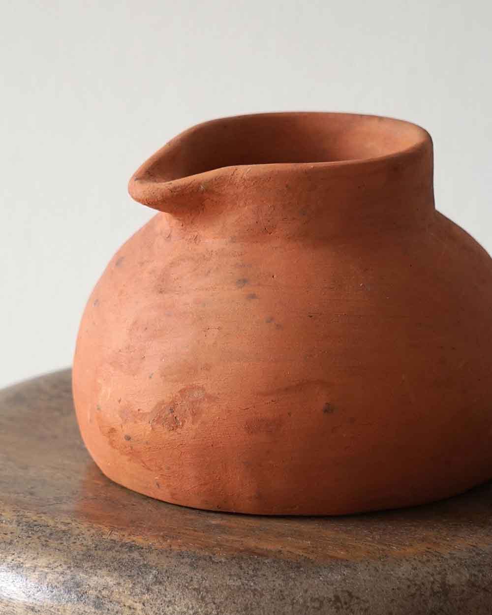 Terracotta pot on a textured surface with a neutral background