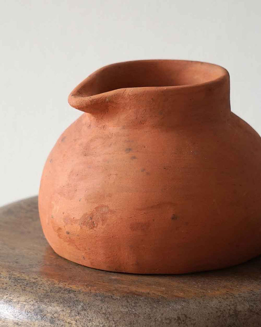 Terracotta pot on a textured surface with a neutral background