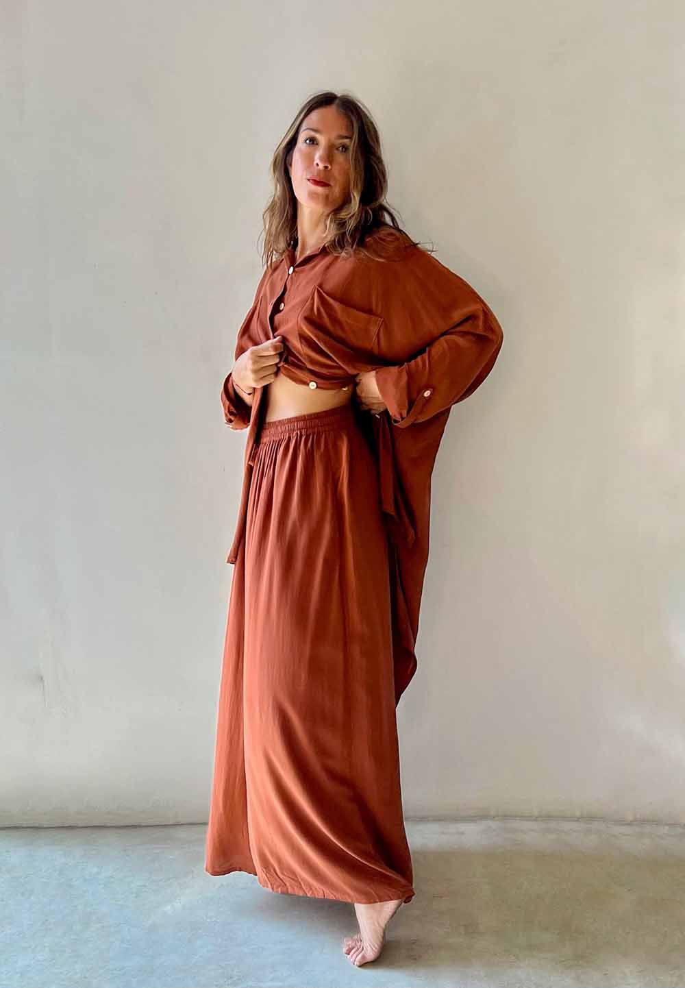 Woman wearing a brown outfit against a plain background