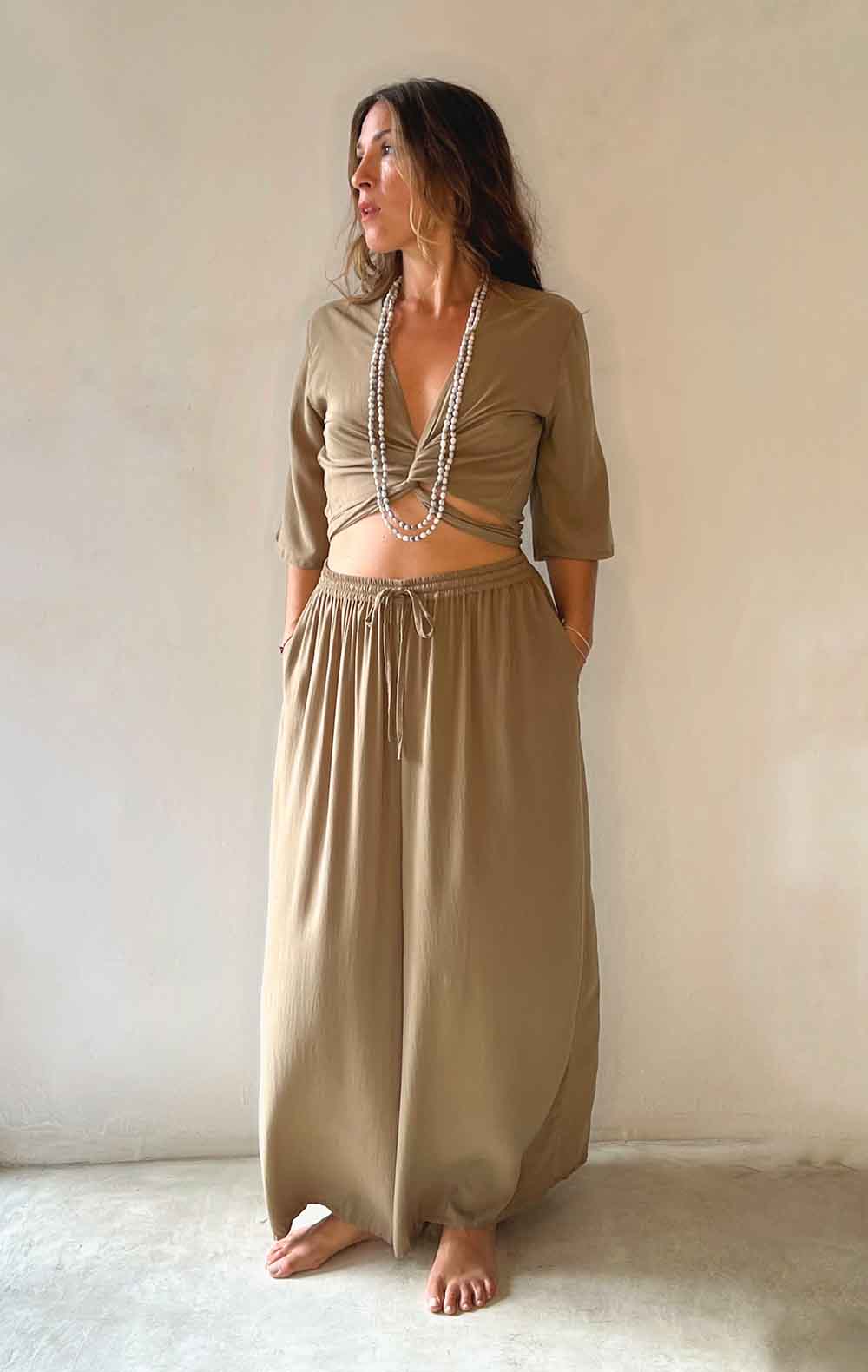 Woman wearing a beige outfit with a plain background