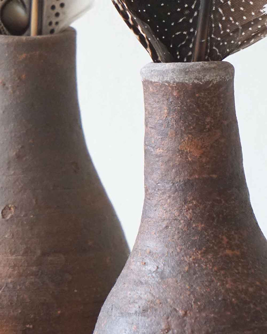 Two rustic brown ceramic vases with a blurred background