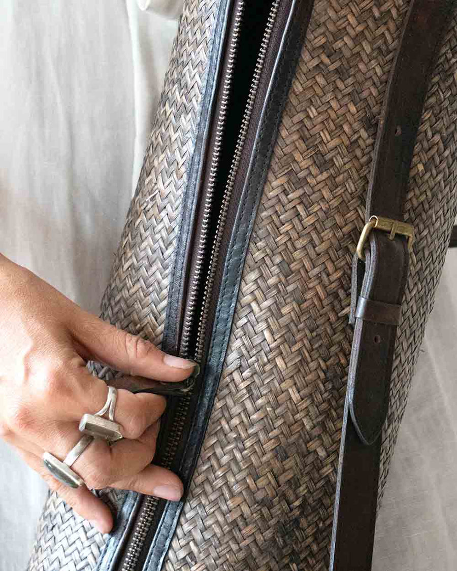Person holding a textured bag with a zipper, wearing a ring.